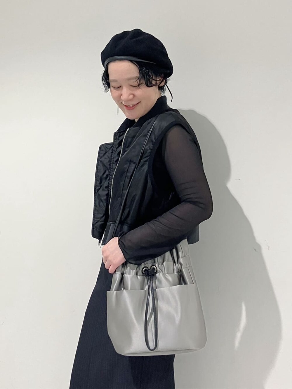 グレー系のショルダーバッグを着用したレディースの秋コーディネートの2枚目の写真