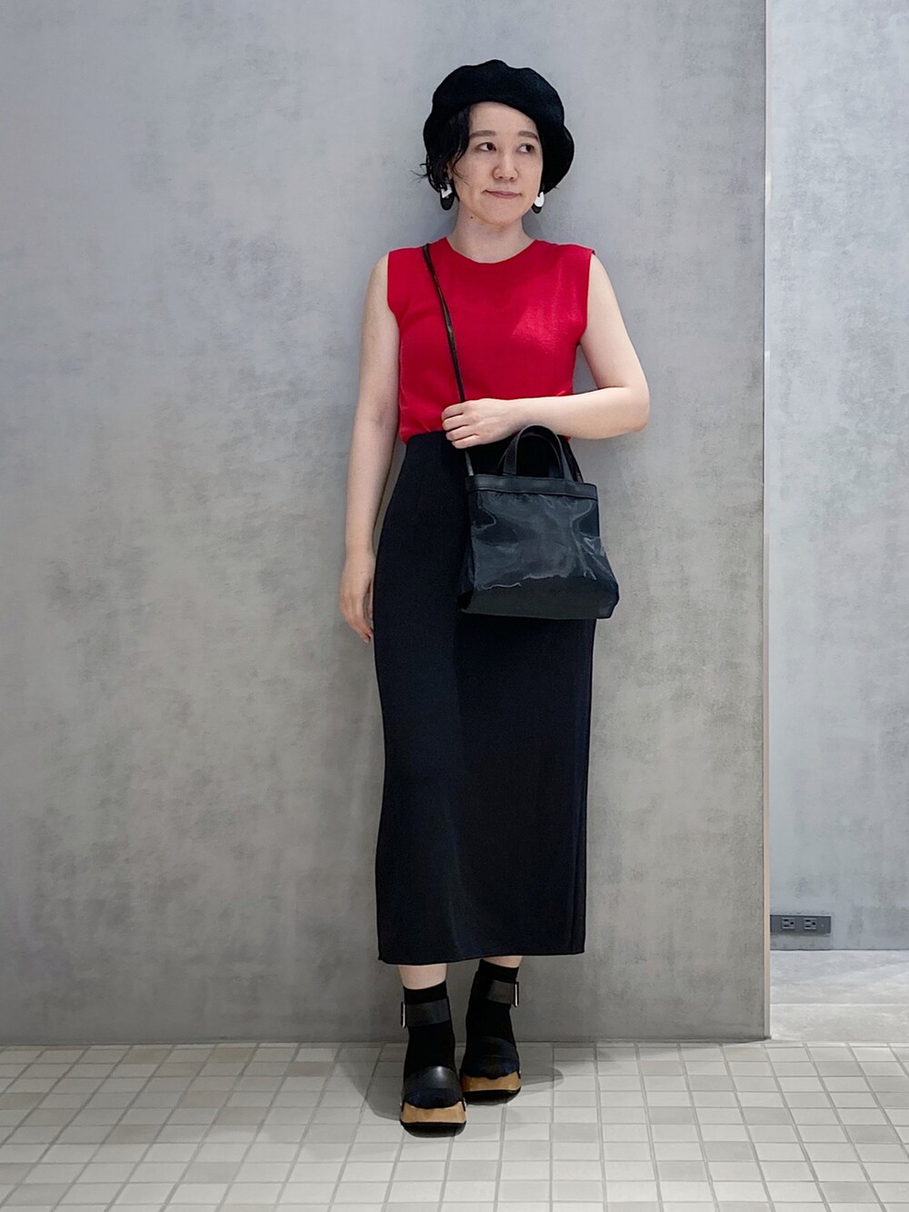 ブラック系のショルダーバッグ、シルバー系の財布を着用したレディースの夏コーディネートの2枚目の写真