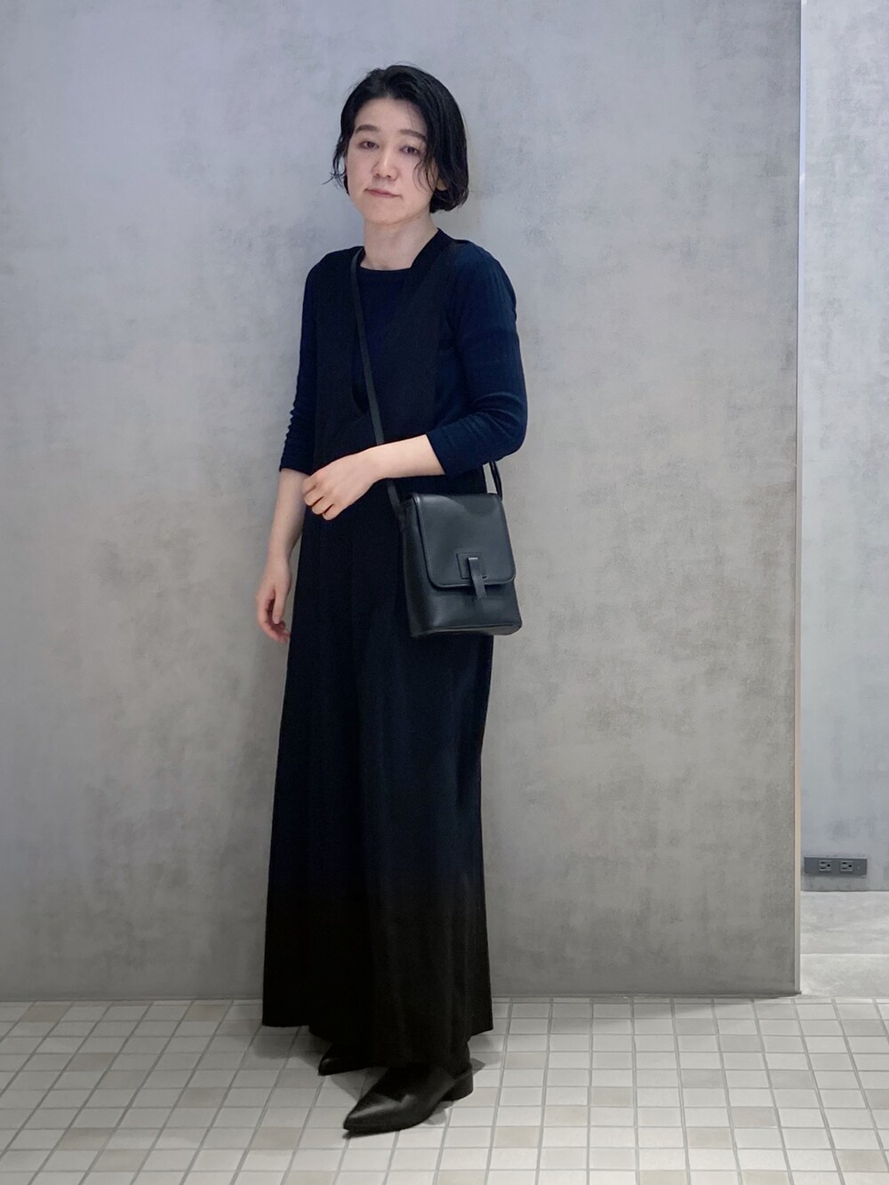 ブラック系のショルダーバッグ、ホワイト系の財布を着用したレディースの春コーディネートの3枚目の写真