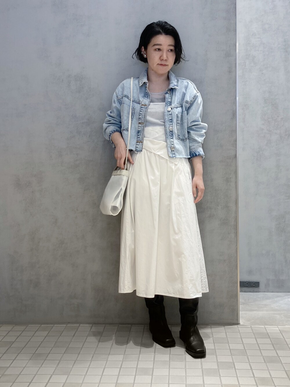 ブラック系のショルダーバッグ、シルバー系のイヤリング、シルバー系のイヤリングを着用したレディースの春コーディネートの2枚目の写真