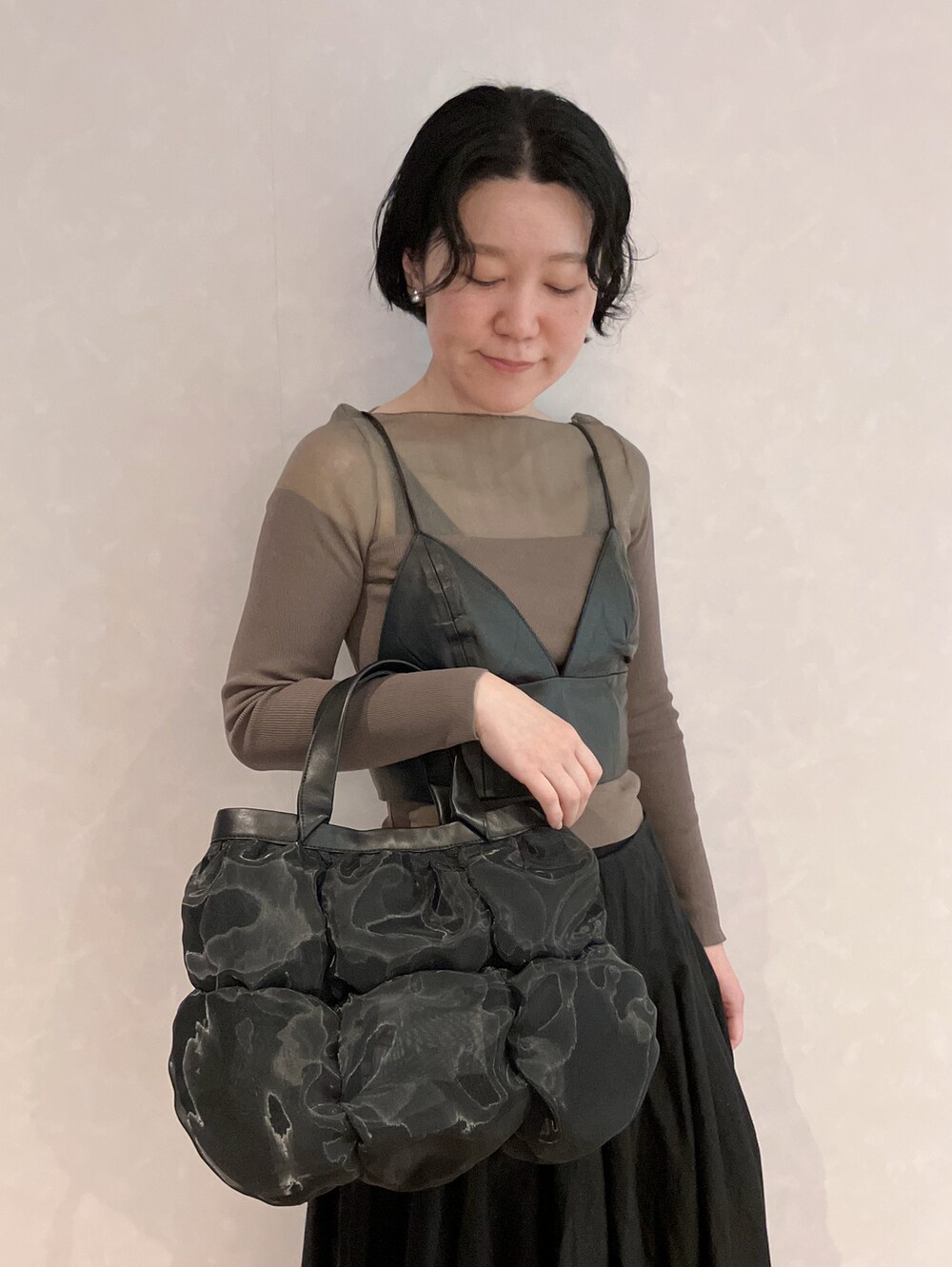 ブラック系のハンドバッグを着用したレディースの春コーディネートの2枚目の写真