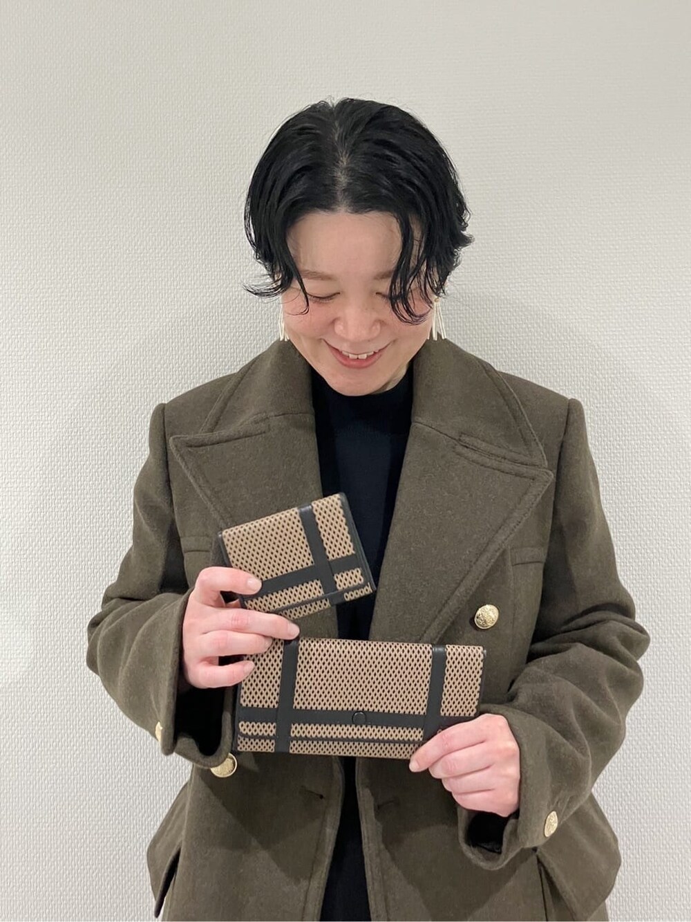 ブラック系の財布、ベージュ系の財布、ブラック系の財布を着用したレディースの冬コーディネートの2枚目の写真