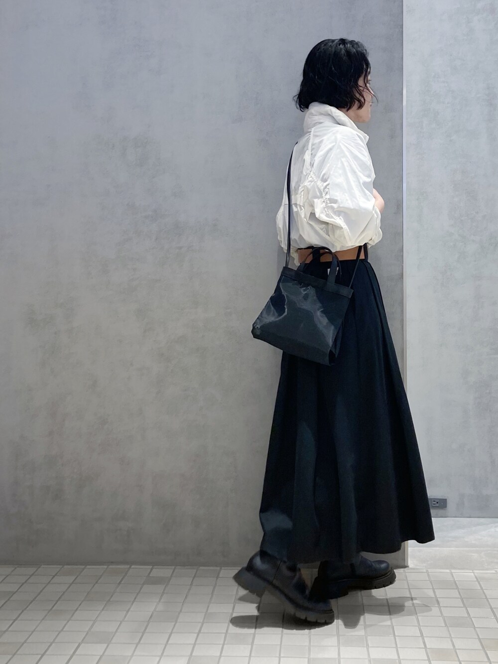 ブラック系のショルダーバッグ、シルバー系のイヤリング、ゴールド系のイヤリングを着用したレディースの春コーディネートの3枚目の写真