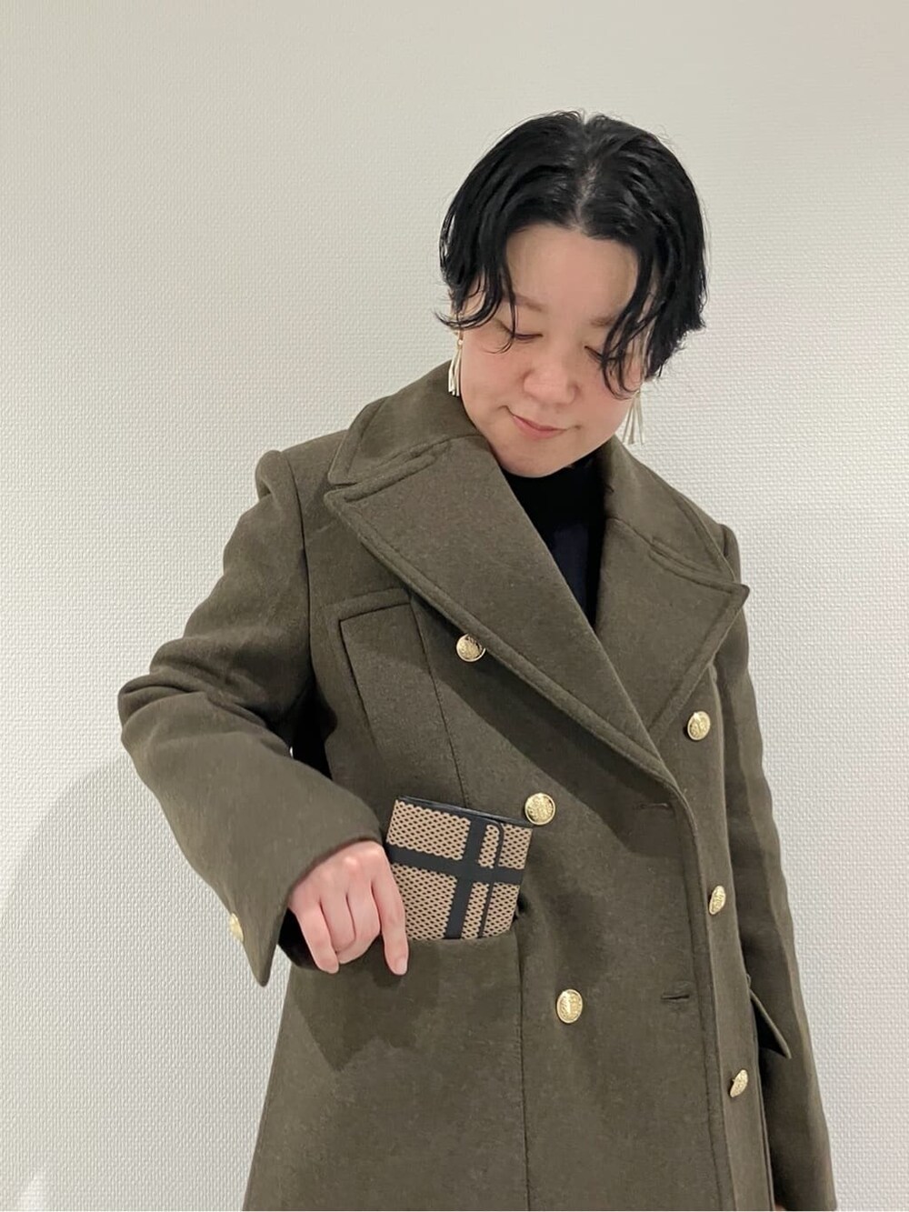 ブラック系の財布、ベージュ系の財布、ブラック系の財布を着用したレディースの冬コーディネートの9枚目の写真