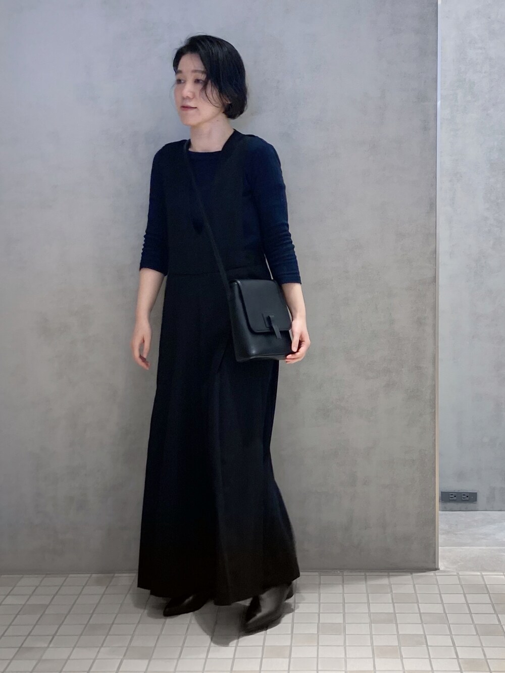 ブラック系のショルダーバッグ、ホワイト系の財布を着用したレディースの春コーディネートの2枚目の写真