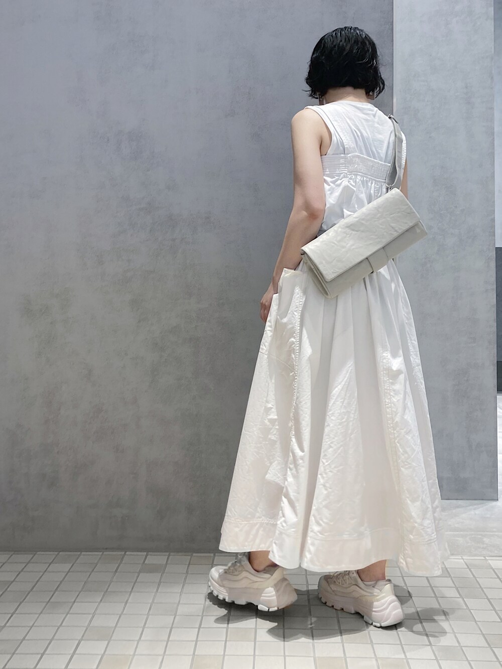 グレー系のショルダーバッグを着用したレディースの夏コーディネートの2枚目の写真