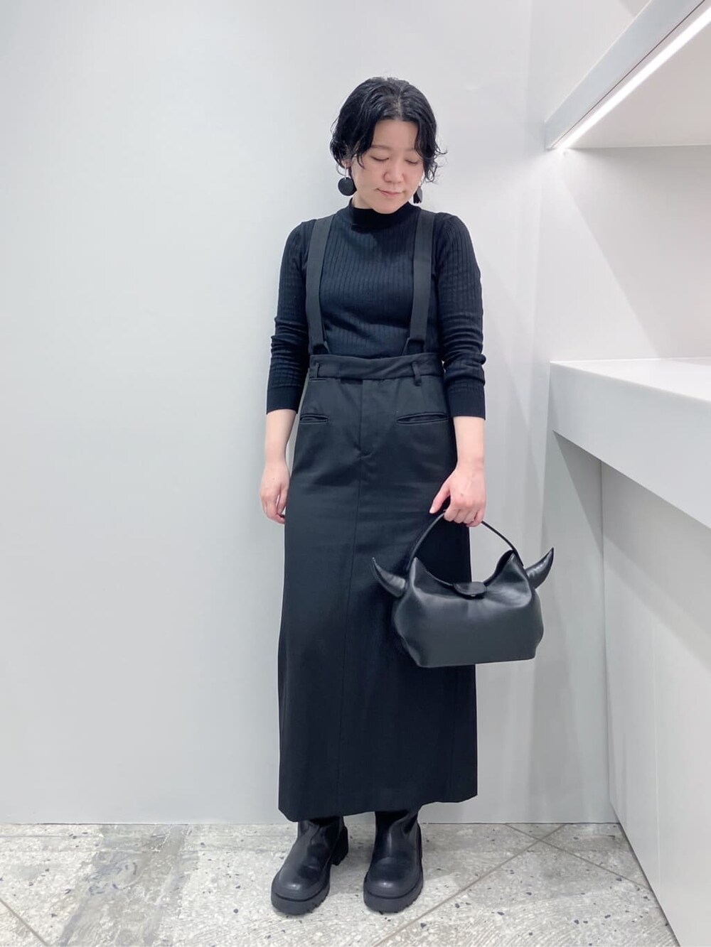 ブラック系のハンドバッグを着用したレディースの秋コーディネートの3枚目の写真