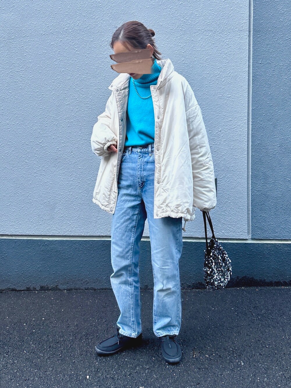 ホワイト系のブルゾン、ブルー系のニット/セーターを着用したレディースの冬コーディネートの2枚目の写真