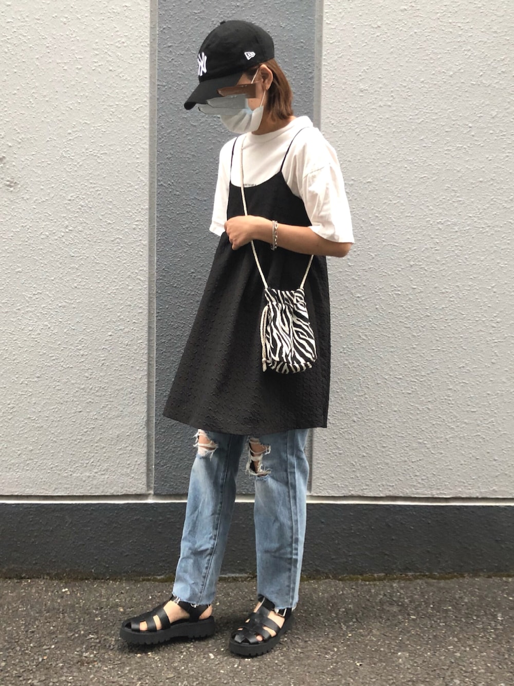 ブラック系のワンピース、ブルー系のデニムパンツ、その他のバッグを着用したレディースの夏コーディネートの2枚目の写真