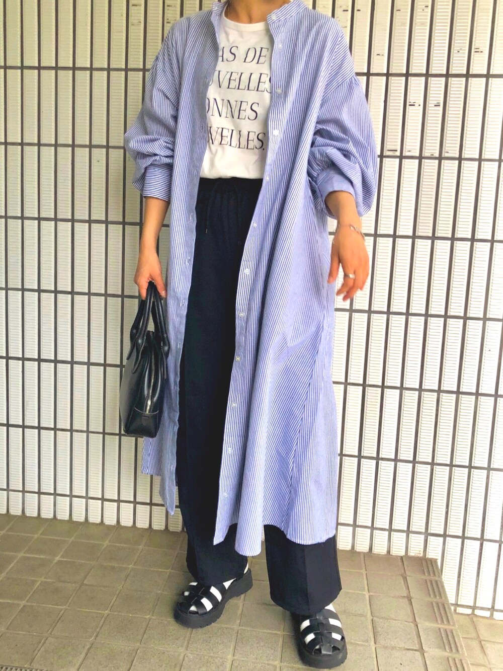 ブラック系のサンダル、ホワイト系のTシャツ/カットソー、ホワイト系のシャツワンピースを着用したレディースの春コーディネートの3枚目の写真