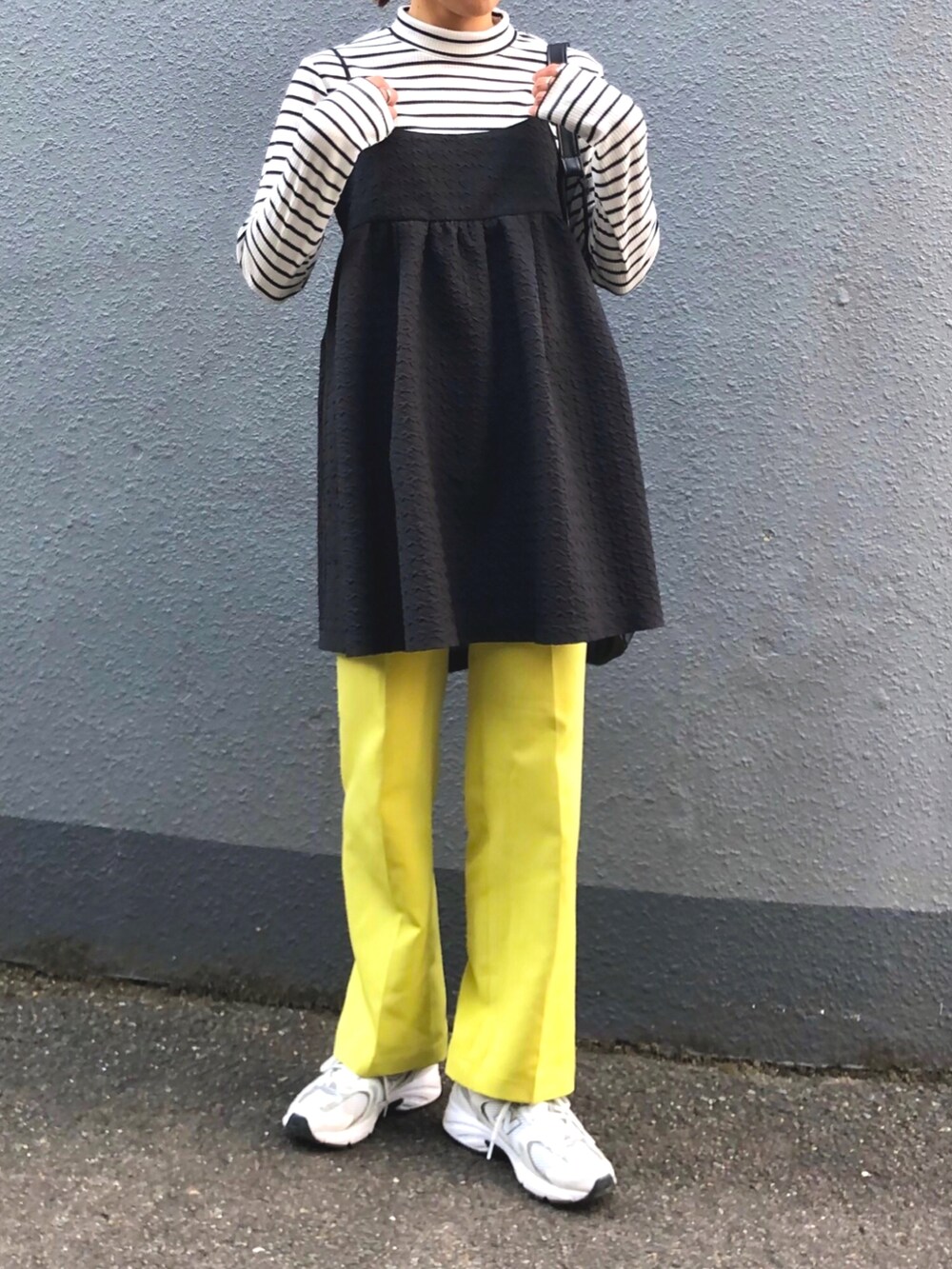 ブラック系のワンピース、ホワイト系のスニーカー、イエロー系のその他パンツを着用したレディースの秋コーディネートの2枚目の写真