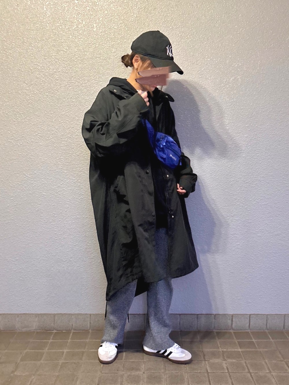 ブラック系のモッズコート、ホワイト系のスニーカー、グレー系のその他パンツを着用したレディースの春コーディネートの2枚目の写真