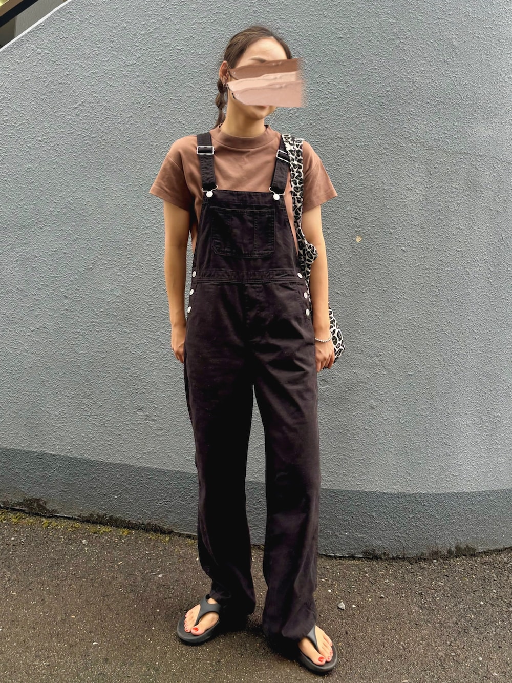 ブラウン系のTシャツ/カットソー、ブラック系のサロペット/オーバーオール、ブラック系のサンダルを着用したレディースの秋コーディネートの2枚目の写真