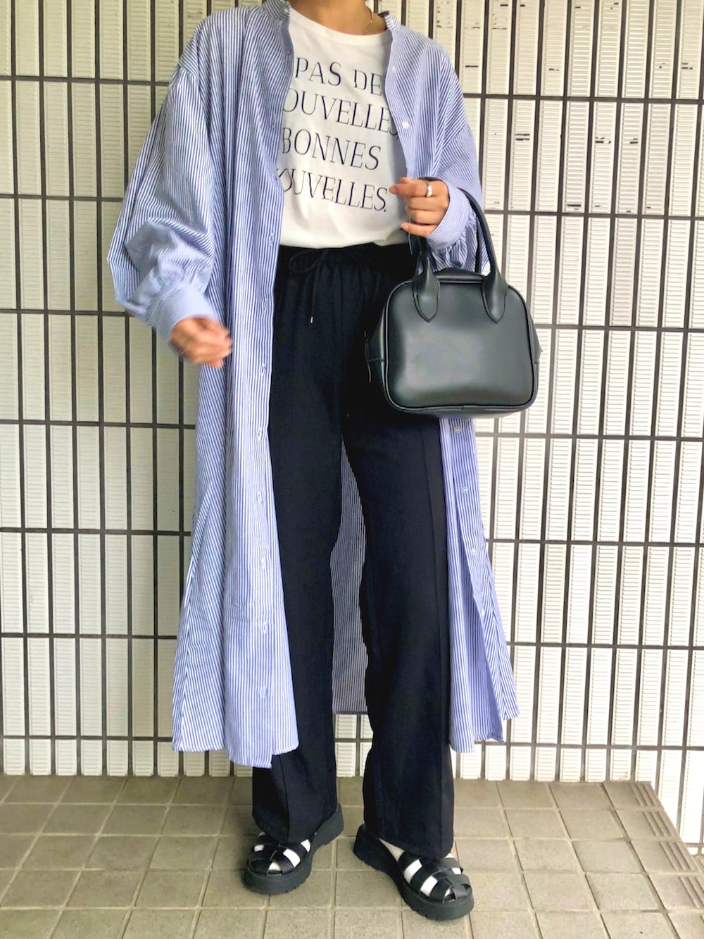 ブラック系のサンダル、ホワイト系のTシャツ/カットソー、ホワイト系のシャツワンピースを着用したレディースの春コーディネートの2枚目の写真