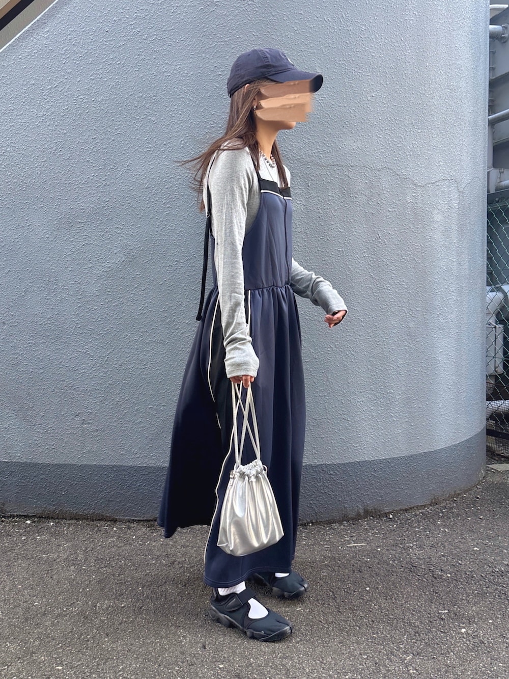グレー系のニット/セーター、グレー系のワンピース、ブラック系のスニーカーを着用したレディースの秋コーディネートの3枚目の写真