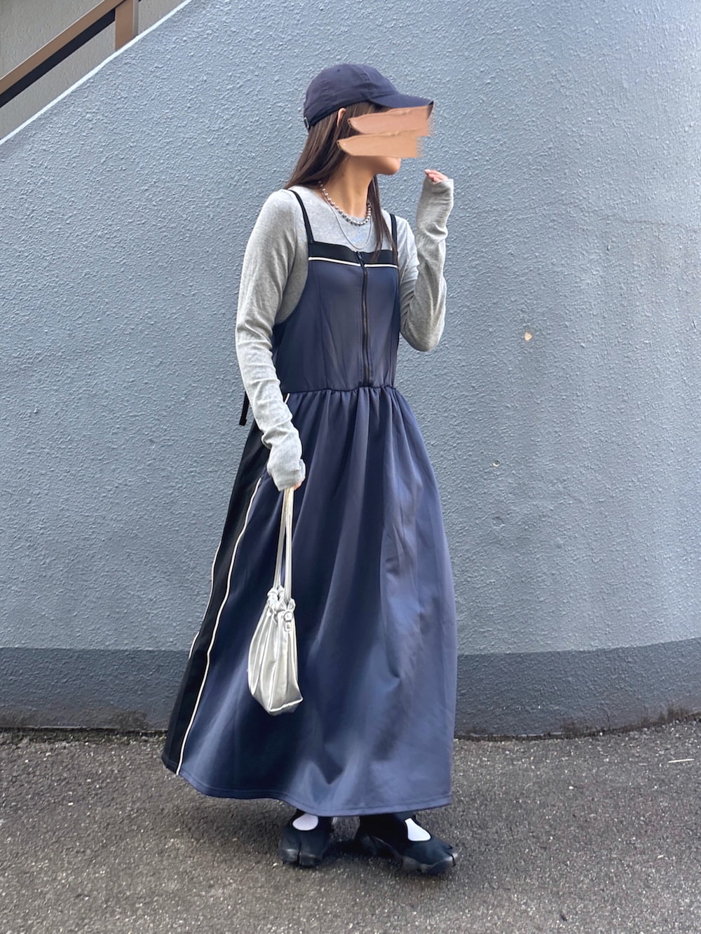 グレー系のニット/セーター、グレー系のワンピース、ブラック系のスニーカーを着用したレディースの秋コーディネートの2枚目の写真