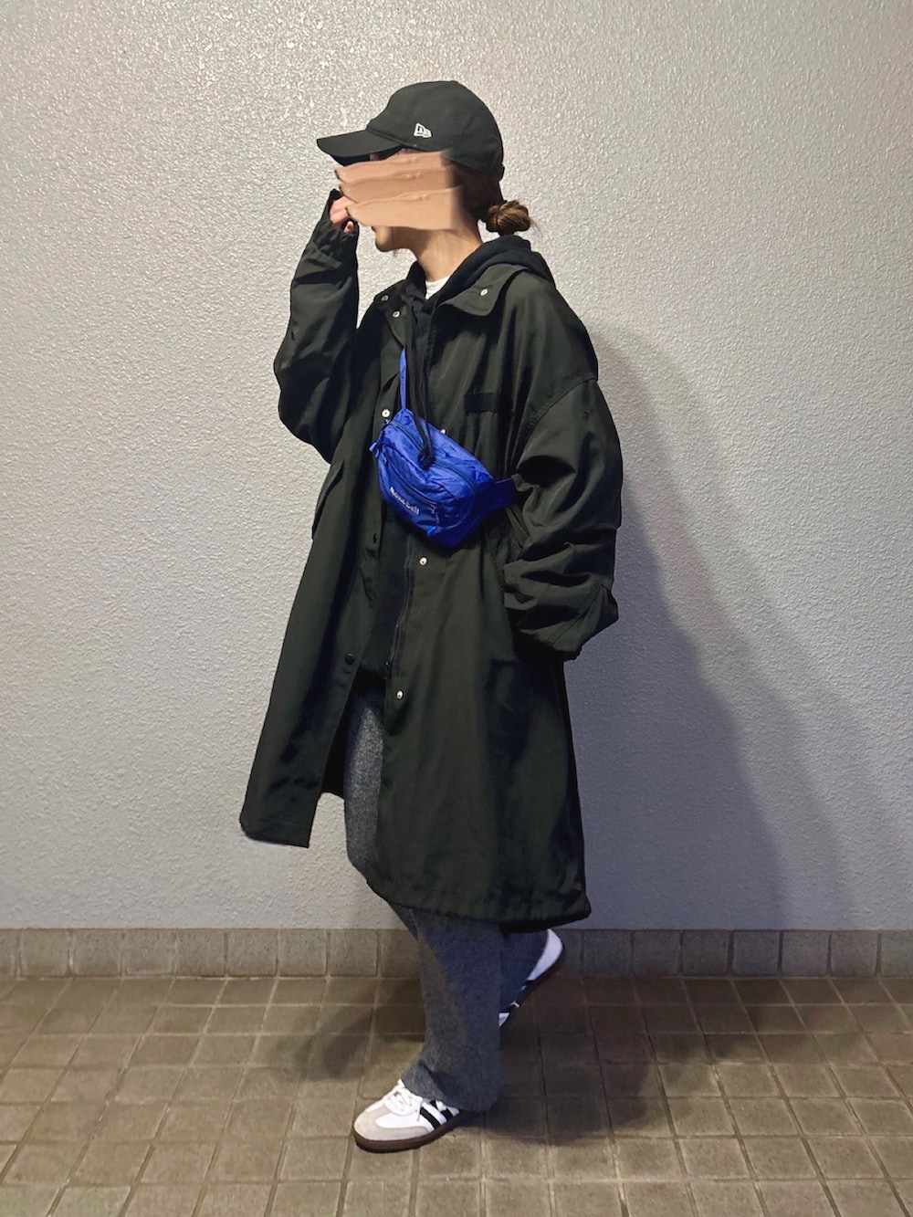 ブラック系のモッズコート、ホワイト系のスニーカー、グレー系のその他パンツを着用したレディースの春コーディネートの3枚目の写真