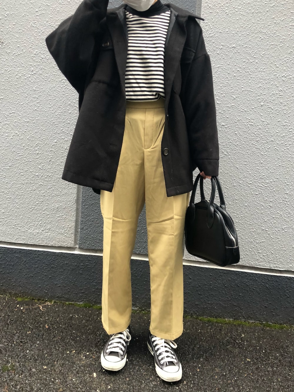 ブラック系のブルゾン、イエロー系のスラックスを着用したレディースの冬コーディネートの2枚目の写真