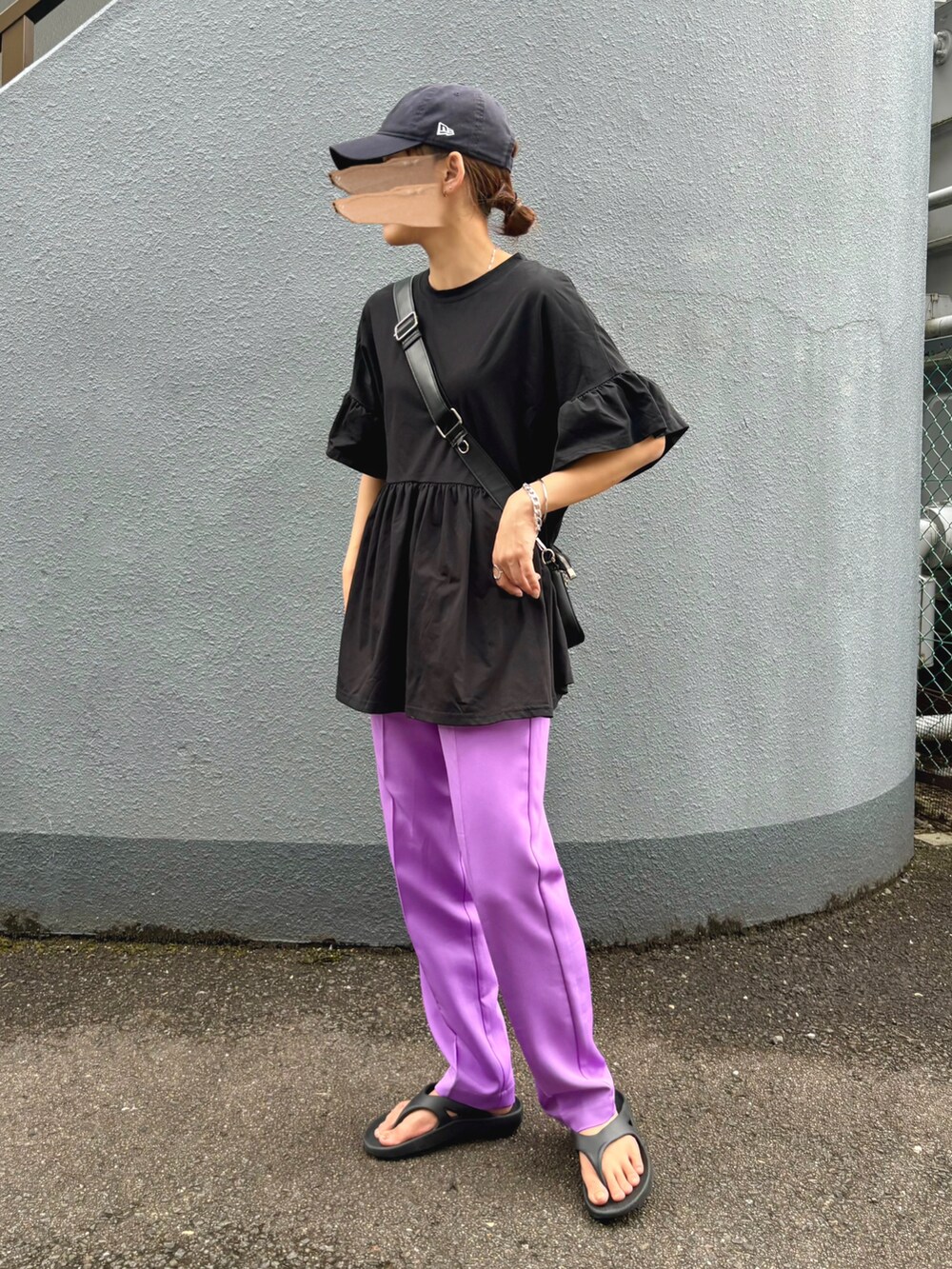 ブラック系のトップス、パープル系のスラックス、ブラック系のサンダルを着用したレディースの夏コーディネートの3枚目の写真