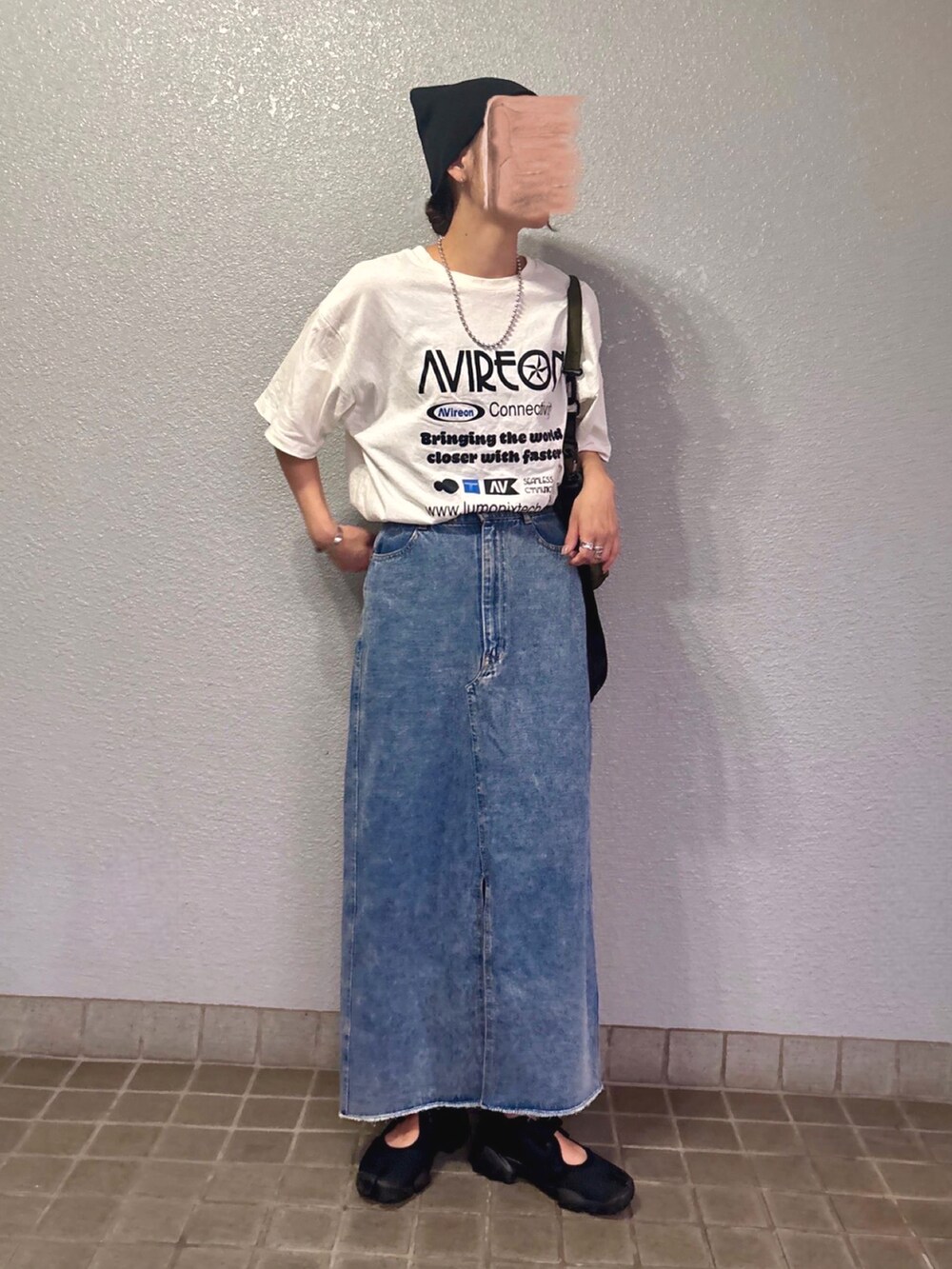 ホワイト系のTシャツ/カットソー、ブラック系のスニーカー、ブルー系のデニムスカートを着用したレディースの夏コーディネートの3枚目の写真