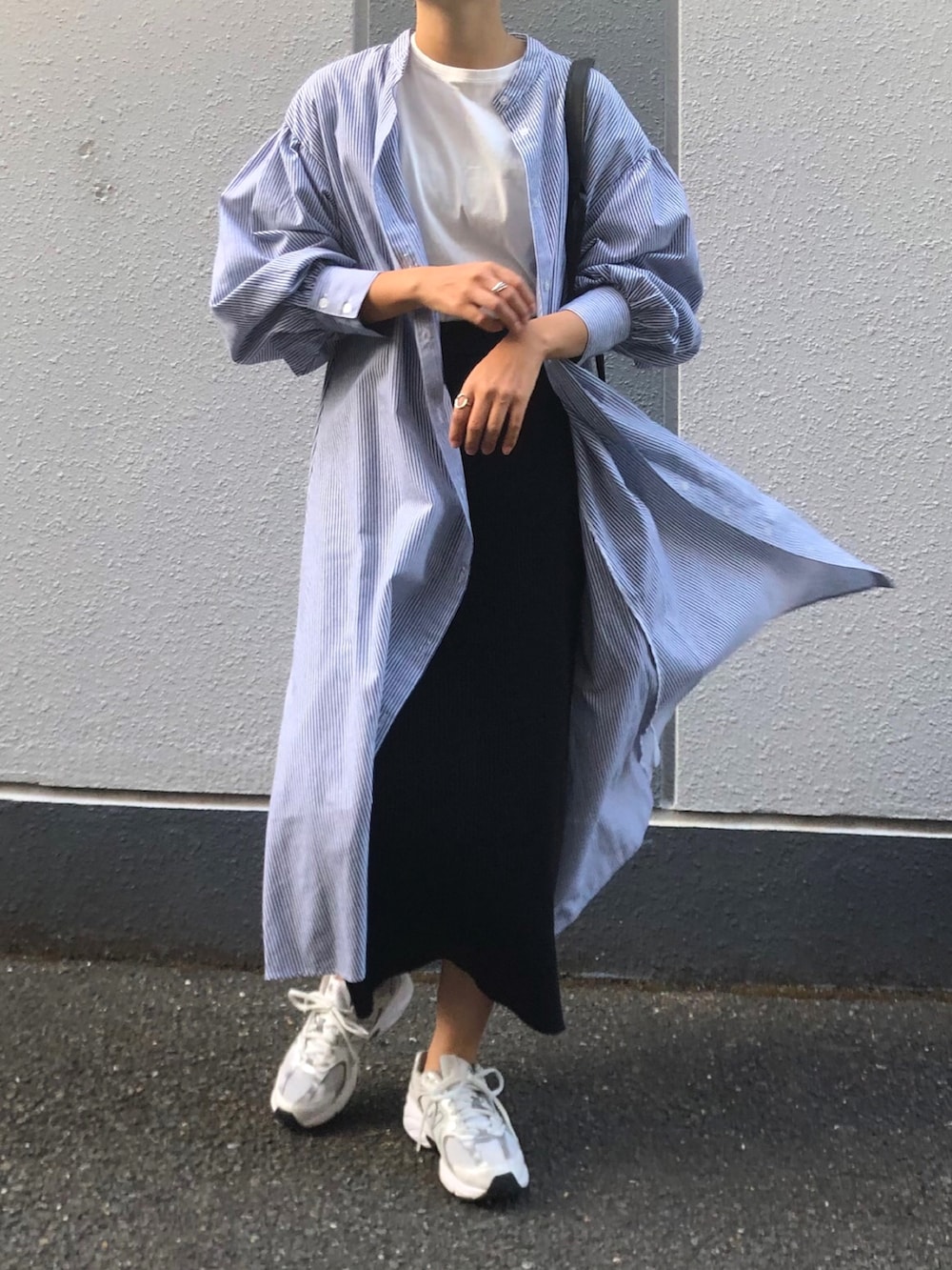 ブラック系のスカート、ホワイト系のTシャツ/カットソー、ホワイト系のスニーカーを着用したレディースの秋コーディネートの2枚目の写真