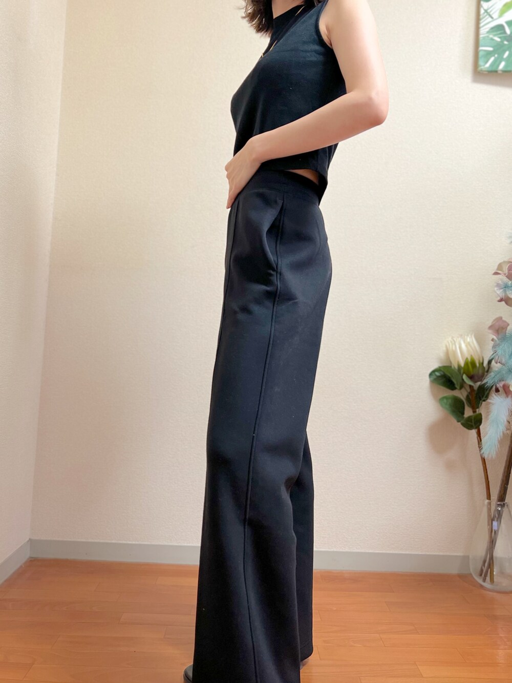 ブラック系のタンクトップ、ブラック系のサンダル、ブラック系のパンツを着用したレディースの夏コーディネートの3枚目の写真