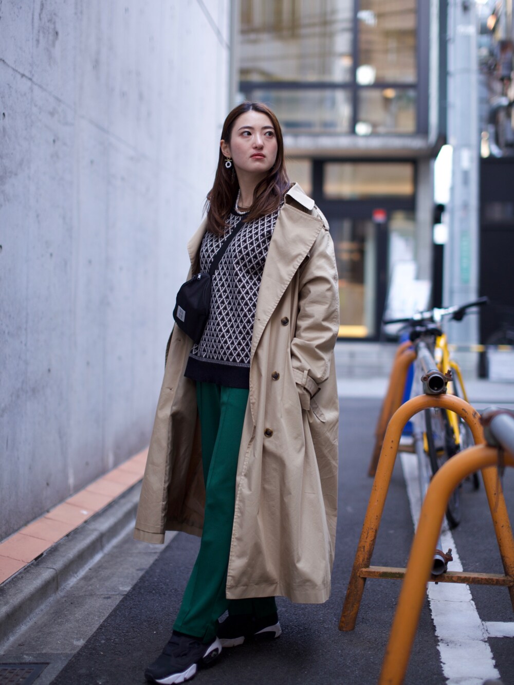 ブラック系のスニーカー、グリーン系のその他パンツ、ブラウン系のトレンチコートを着用したレディースの春コーディネートの2枚目の写真