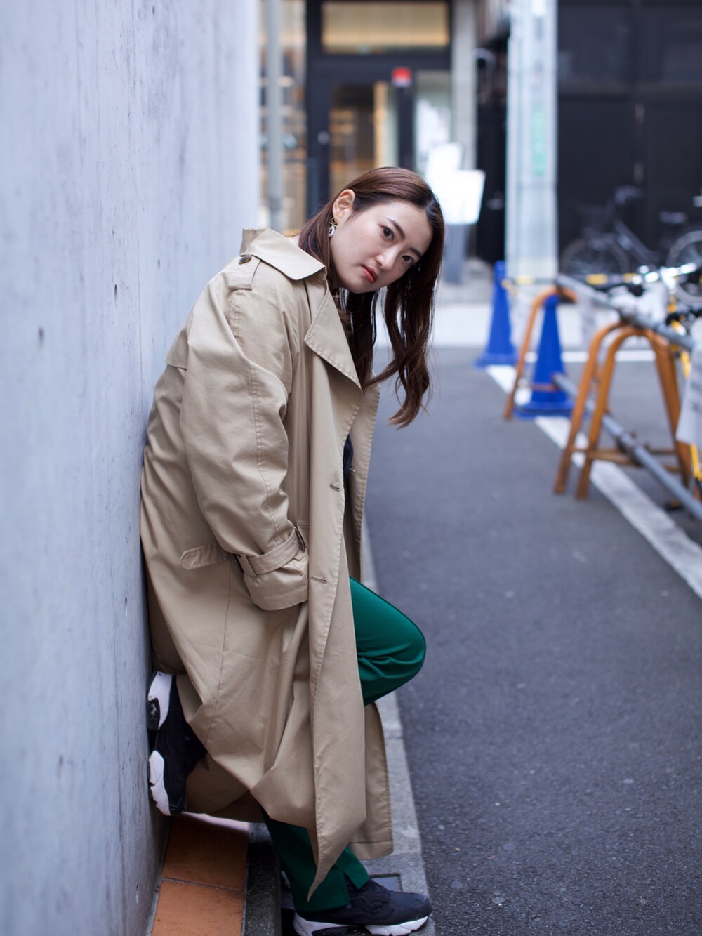 ブラック系のスニーカー、グリーン系のその他パンツ、ブラウン系のトレンチコートを着用したレディースの春コーディネートの3枚目の写真