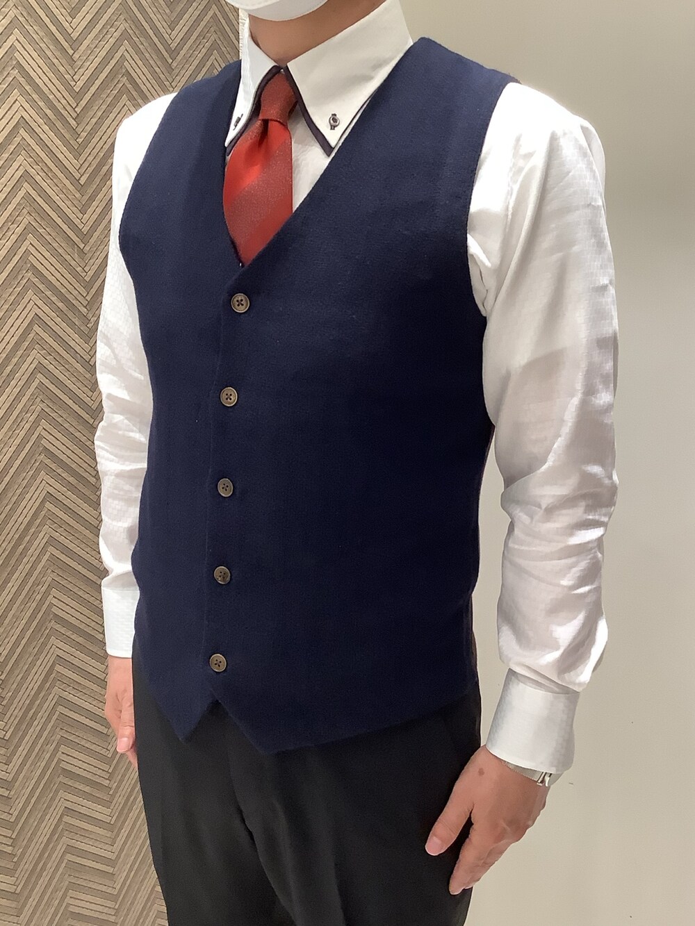 ブルー系のベスト、ホワイト系のビジネスシャツを着用したメンズの秋コーディネートの2枚目の写真