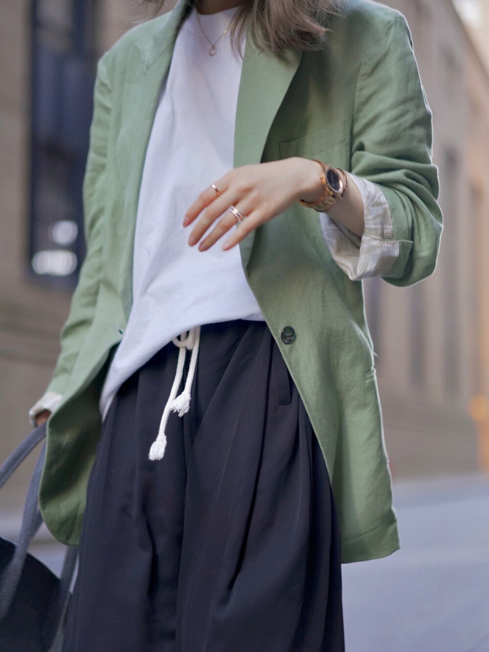 ブラック系のアナログ腕時計を着用したレディースの夏コーディネートの2枚目の写真