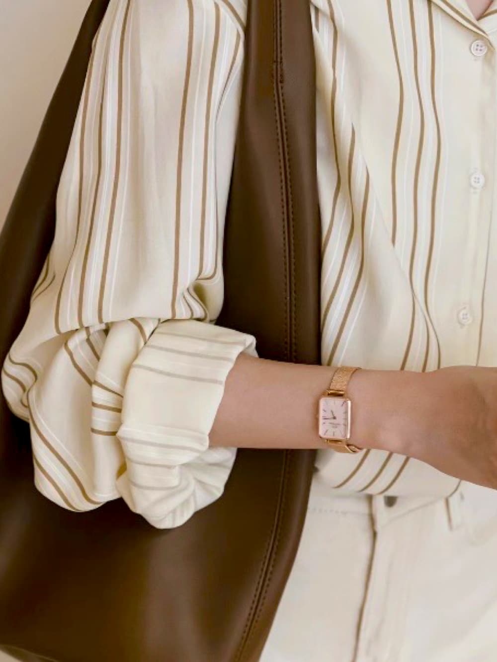 ピンク系のアナログ腕時計を着用したレディースの春コーディネートの2枚目の写真