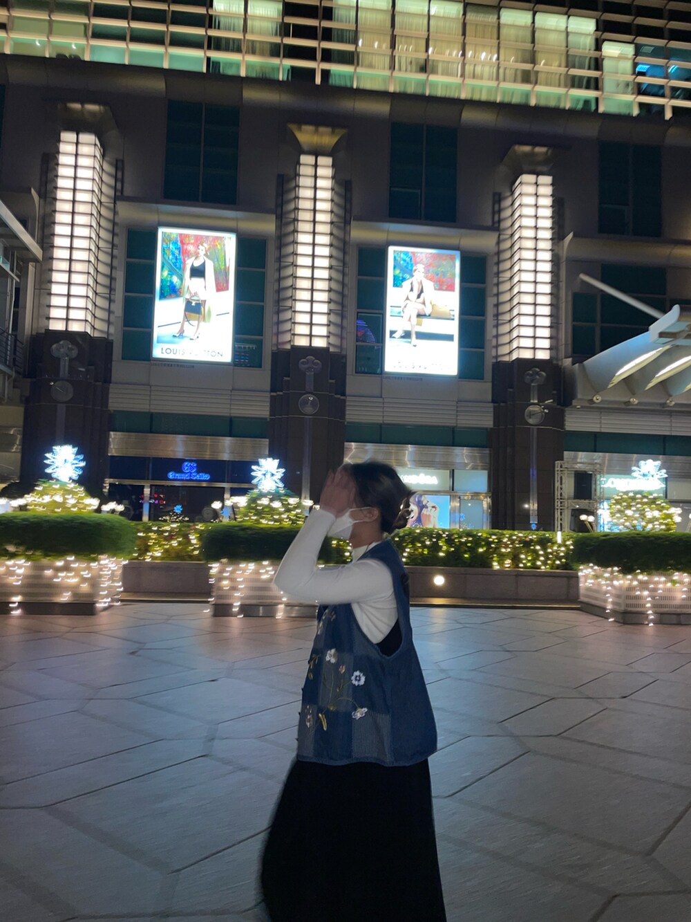 ブラック系のジャンパースカート、ブルー系のその他アウター、ブラック系のブーツを着用したレディースの春コーディネートの2枚目の写真