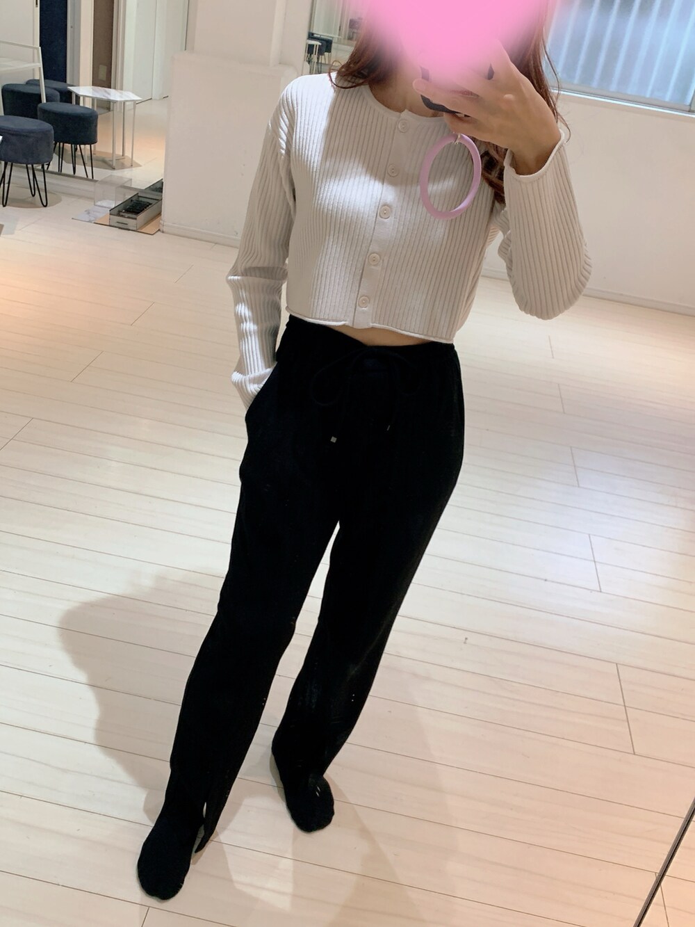 ブラック系のスラックス、グレー系のジャケット/アウター、ホワイト系のカーディガン/ボレロを着用したレディースの冬コーディネートの2枚目の写真