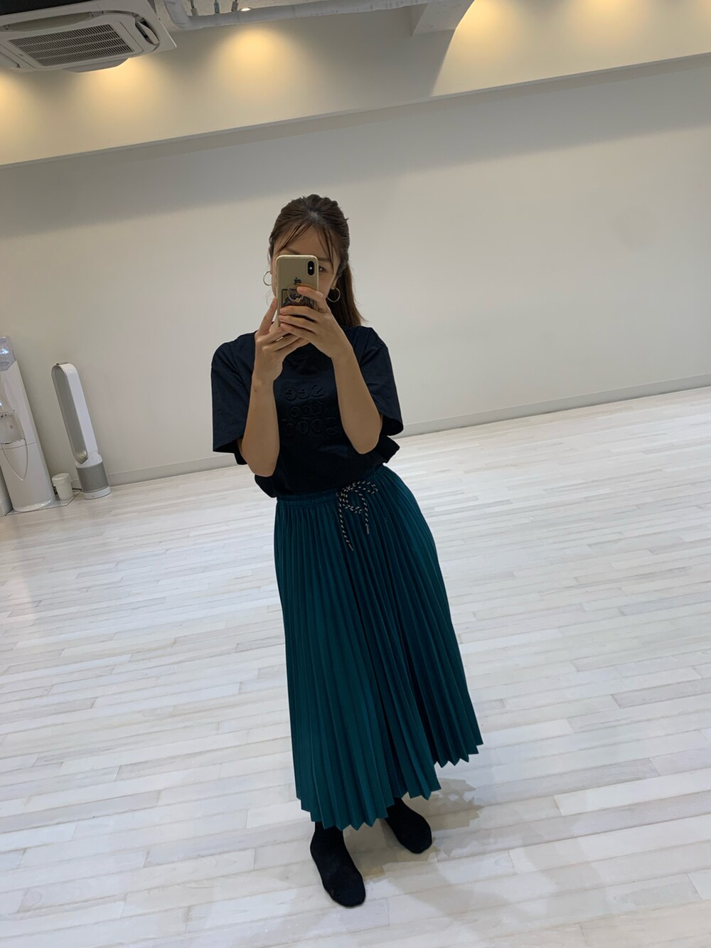 グリーン系のスカート、ブラック系のTシャツ/カットソーを着用したレディースの夏コーディネートの2枚目の写真