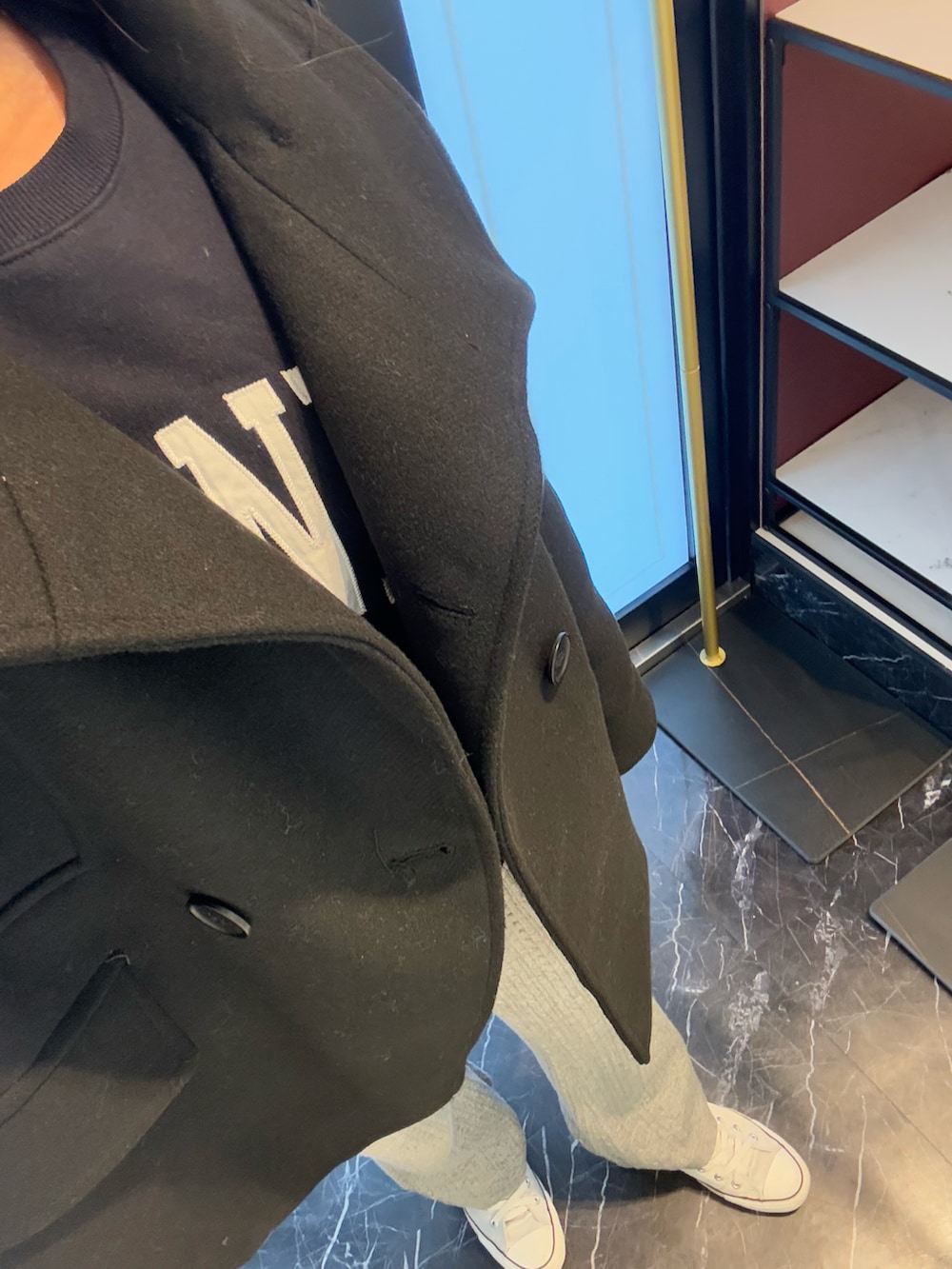 ブルー系のスウェット、グレー系のパンツ、シルバー系のスニーカーを着用したレディースの冬コーディネートの2枚目の写真