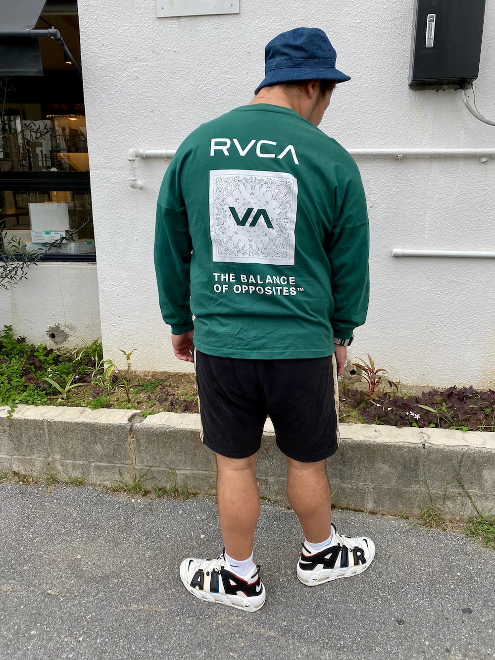 グリーン系のTシャツ/カットソー、ブラック系のその他パンツ、その他のスニーカーを着用したメンズの春コーディネートの2枚目の写真