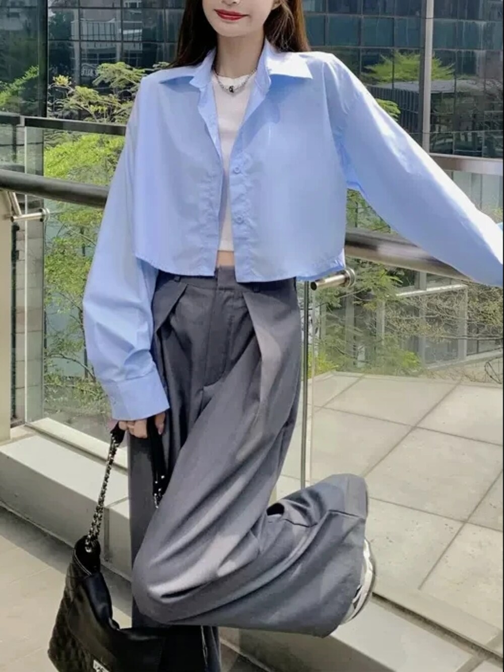 グレー系のパンツ、ホワイト系のベスト、ブルー系のシャツ/ブラウスを着用したレディースの春コーディネートの5枚目の写真