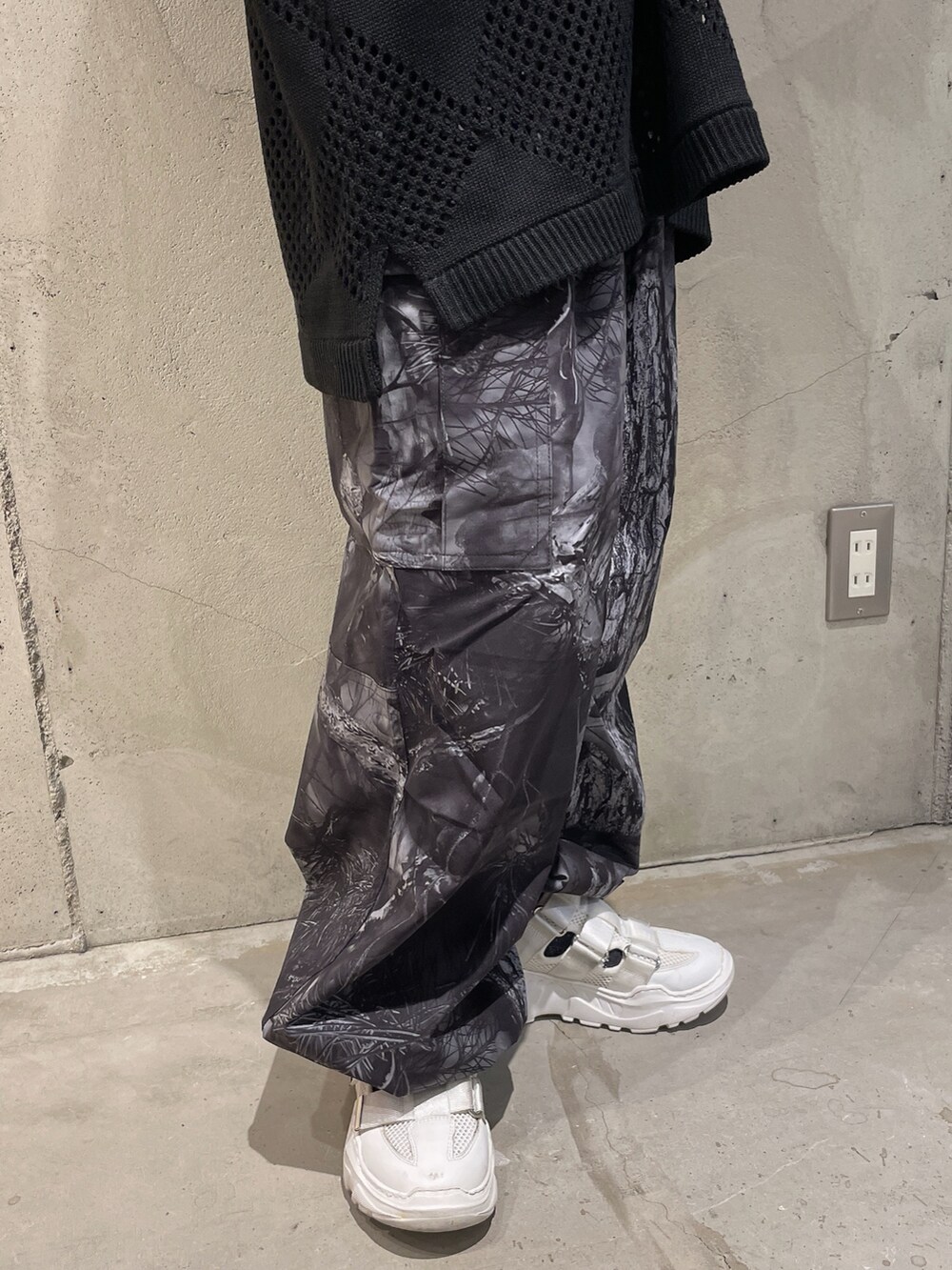 ブラック系のニット/セーター、グレー系のカーゴパンツ、シルバー系のネックレスを着用したレディースの夏コーディネートの4枚目の写真