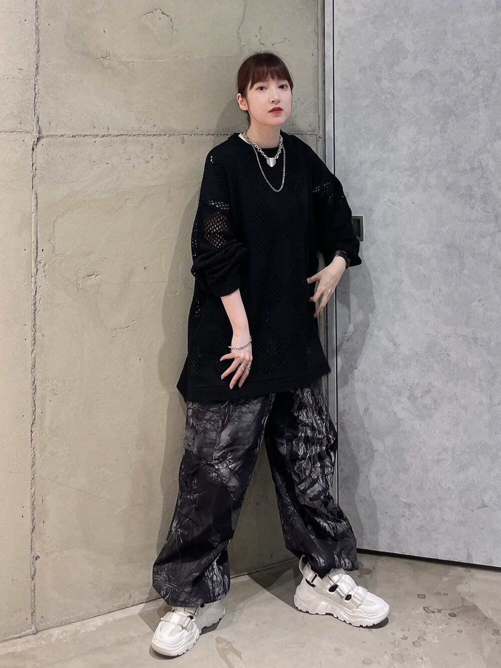 ブラック系のニット/セーター、グレー系のカーゴパンツ、シルバー系のネックレスを着用したレディースの夏コーディネートの2枚目の写真