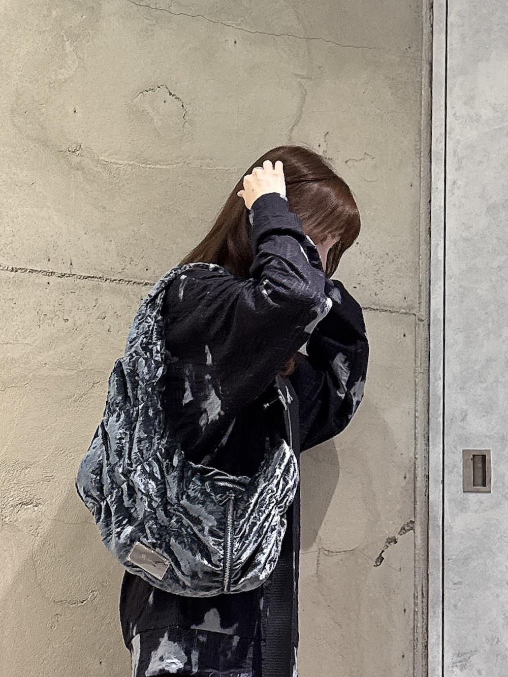 グレー系のショルダーバッグ、ブラック系のTシャツ/カットソー、シルバー系のネックレスを着用したレディースの秋コーディネートの3枚目の写真