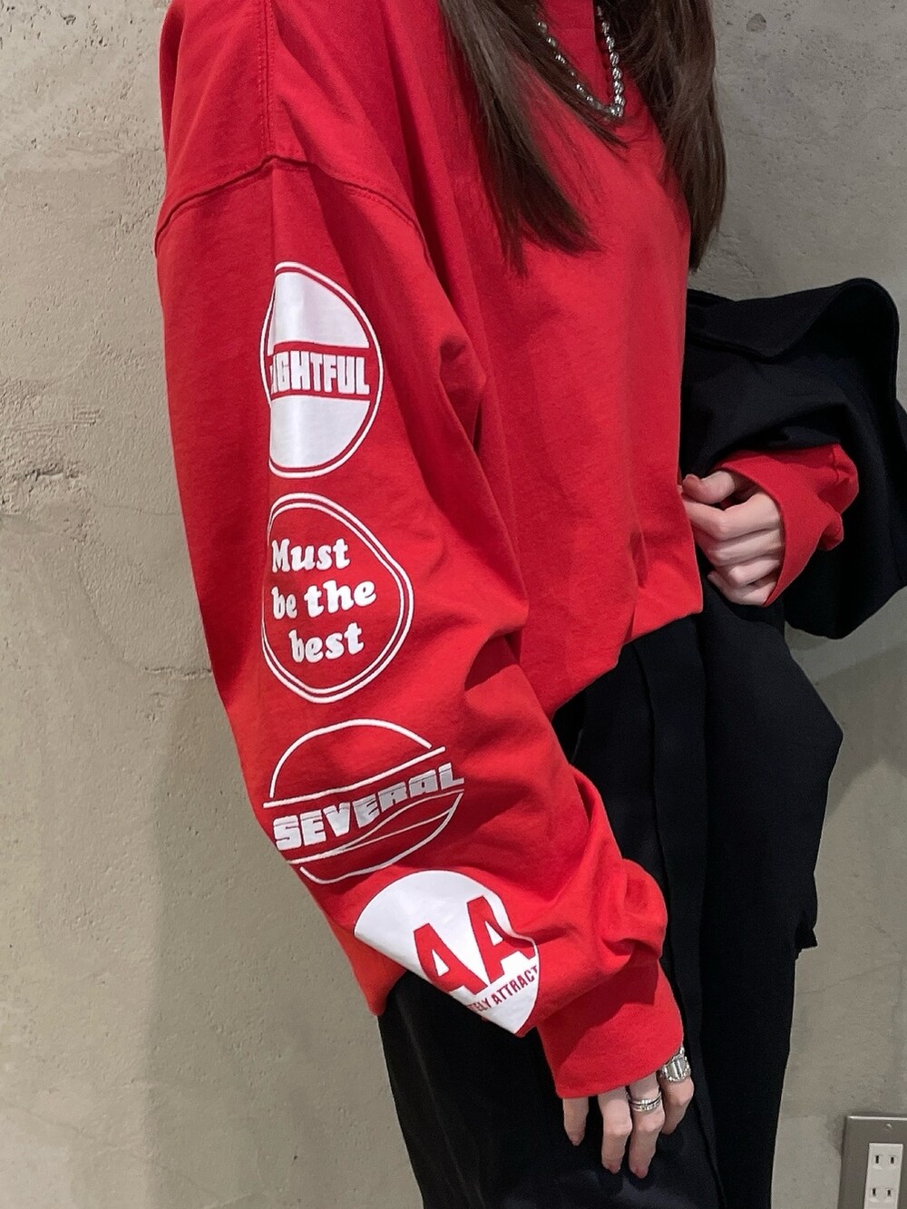 ブラック系のブルゾン、レッド系のTシャツ/カットソー、シルバー系のネックレスを着用したレディースの春コーディネートの2枚目の写真