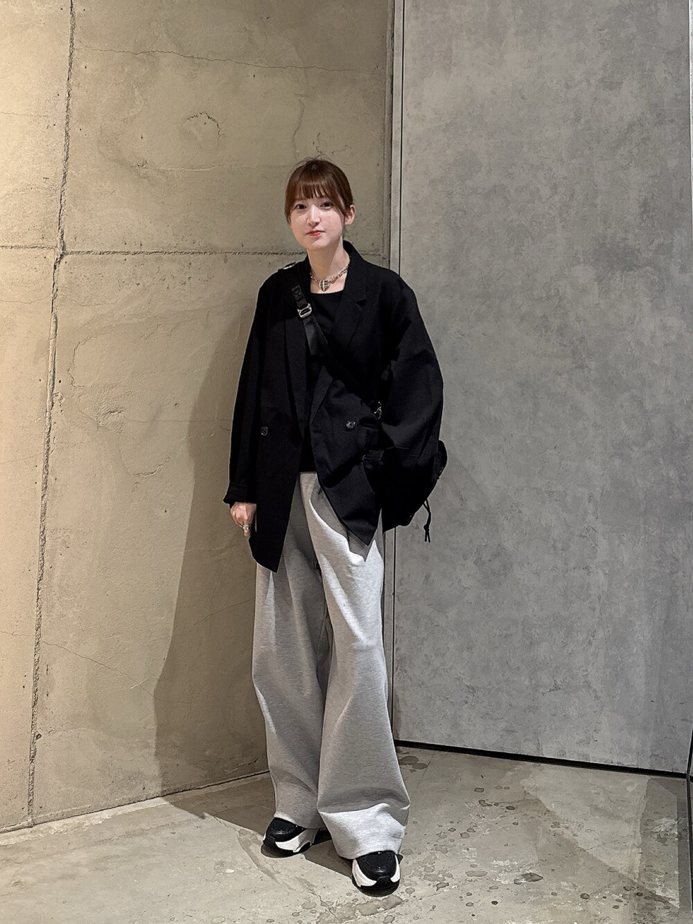 グレー系のその他パンツ、ブラック系のテーラードジャケット、ブラック系のバックパック/リュックを着用したレディースの秋コーディネートの2枚目の写真