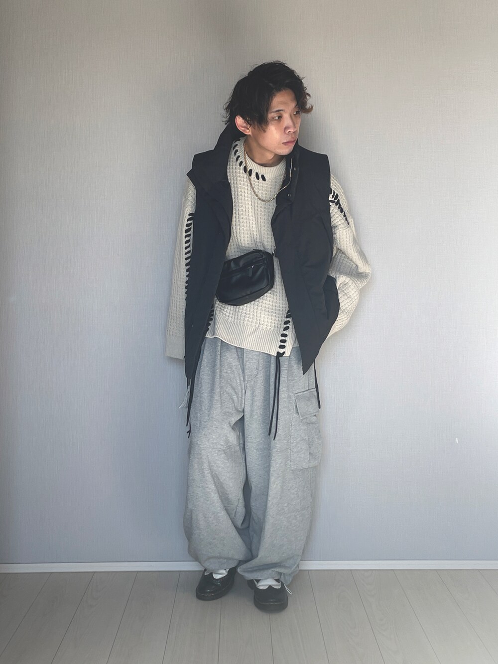 ブラック系のダウンベスト、グレー系のスウェットパンツ、ブラック系のシューズを着用したメンズの冬コーディネートの4枚目の写真