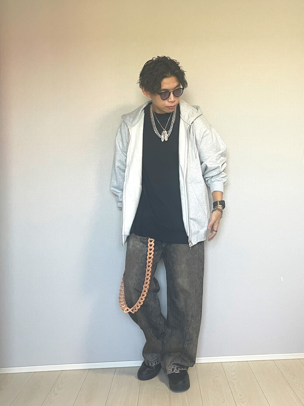 ブラック系のスニーカー、ブルー系のデニムパンツ、グレー系のパーカーを着用したメンズの秋コーディネートの5枚目の写真