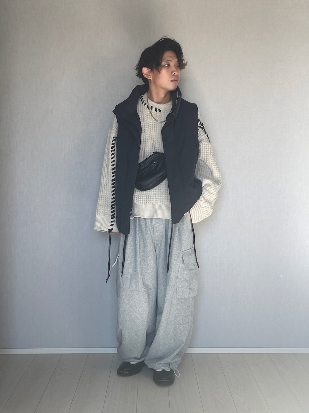 ブラック系のダウンベスト、グレー系のスウェットパンツ、ブラック系のシューズを着用したメンズの冬コーディネートの3枚目の写真