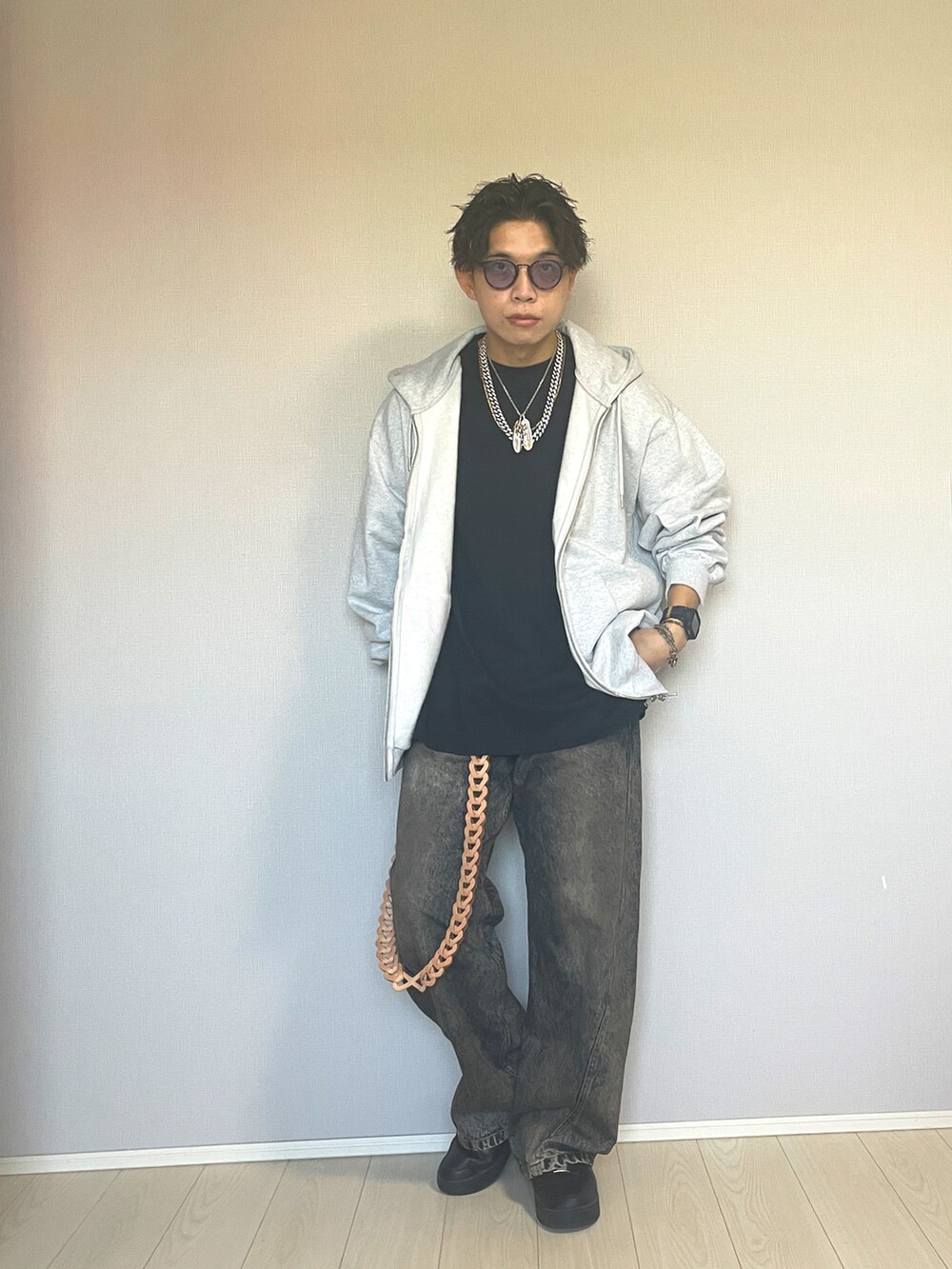 ブラック系のスニーカー、ブルー系のデニムパンツ、グレー系のパーカーを着用したメンズの秋コーディネートの4枚目の写真