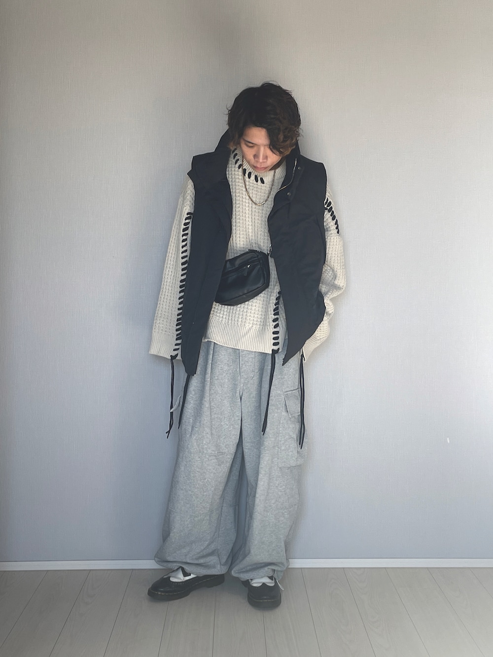 ブラック系のダウンベスト、グレー系のスウェットパンツ、ブラック系のシューズを着用したメンズの冬コーディネートの5枚目の写真