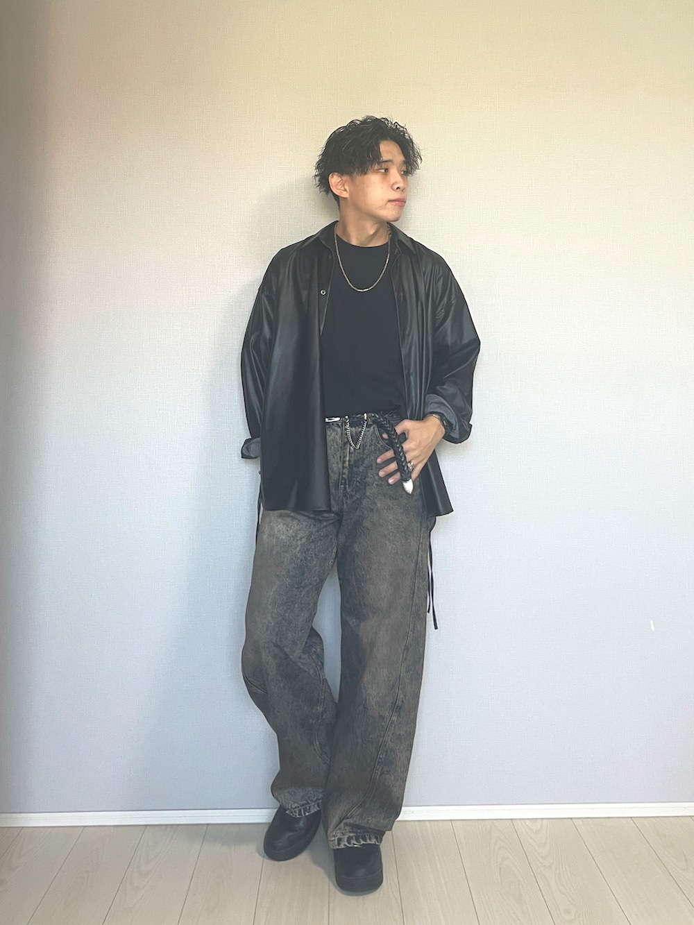 ブラック系のスニーカー、ブルー系のデニムパンツ、ブラック系のTシャツ/カットソーを着用したメンズの秋コーディネートの2枚目の写真