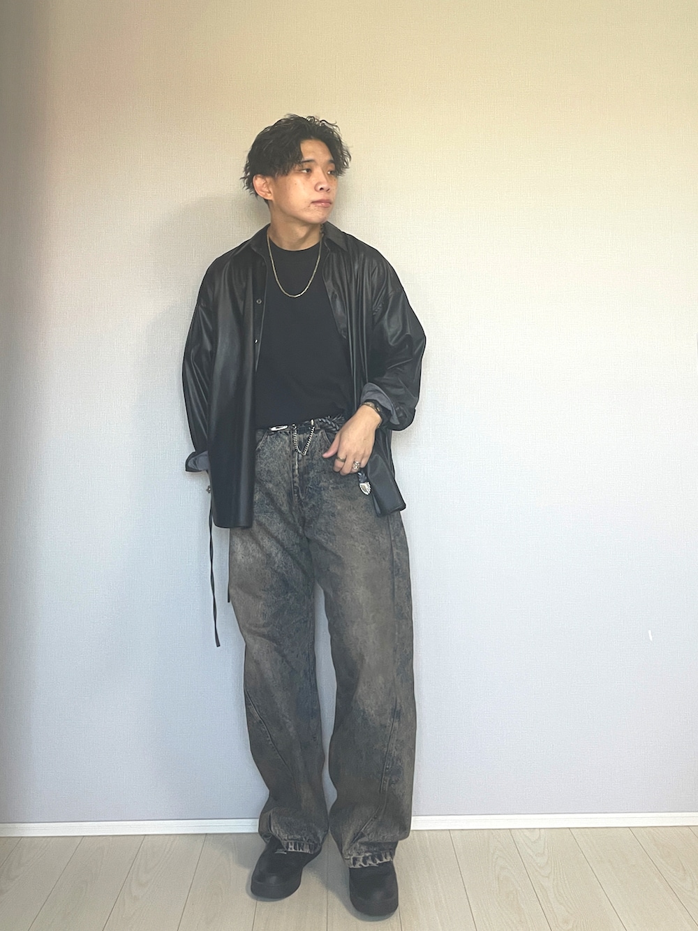 ブラック系のスニーカー、ブルー系のデニムパンツ、ブラック系のTシャツ/カットソーを着用したメンズの秋コーディネートの3枚目の写真