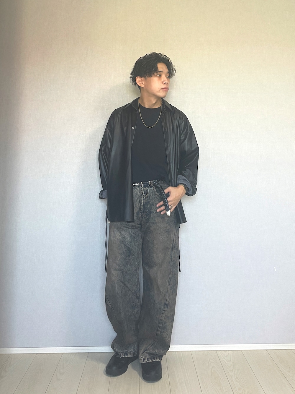 ブラック系のスニーカー、ブルー系のデニムパンツ、ブラック系のTシャツ/カットソーを着用したメンズの秋コーディネートの5枚目の写真